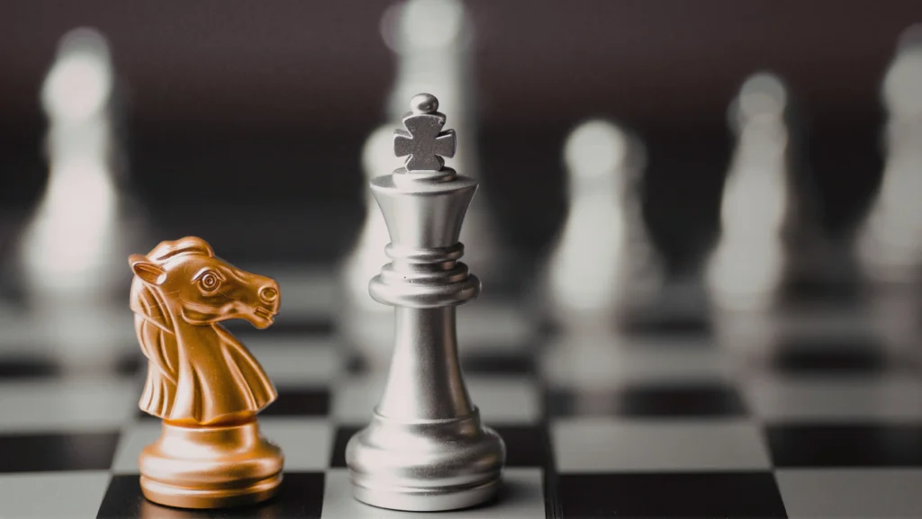 Piezas de ajedrez frente a frente sobre un tablero, representando estrategia, toma de decisiones y análisis estructural en entornos empresariales